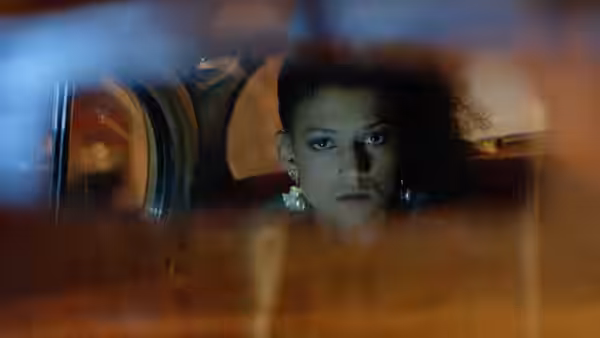 Simone (Cathy Tyson) looking out from the back seat of a car at night