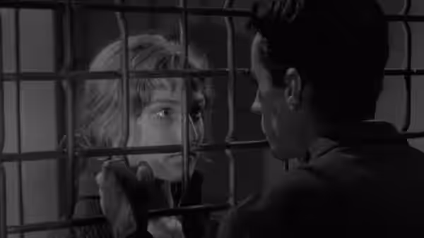 Michel (Martin LaSalle) faces Jeanne (Marika Green) through a barred partition