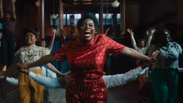 Sofia (Danielle Brooks) dances with outstretched arms as people celebrate around her