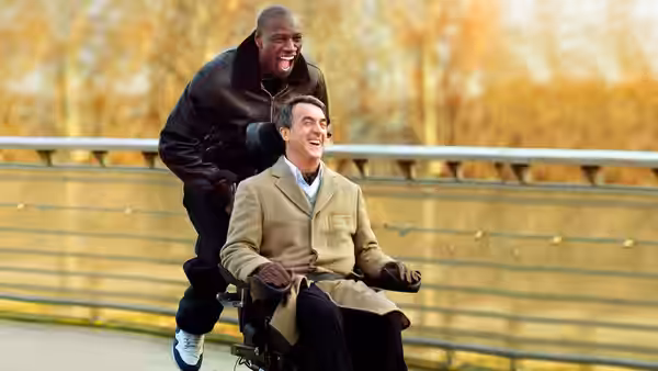 Driss (Omar Sy) pushing Philippe (François Cluzet) in a wheelchair outdoors