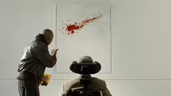 Driss (Omar Sy) pointing at a painting while Philippe (François Cluzet) watches