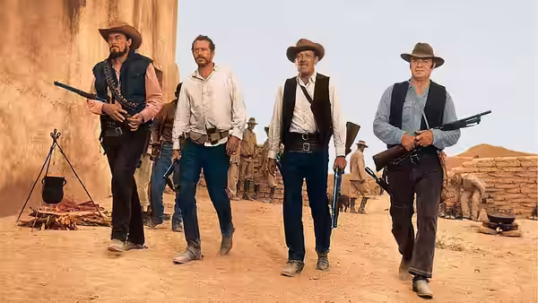 Pike Bishop and three armed men walk through a dusty settlement