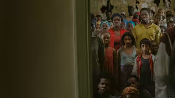 A crowd of people gathers inside a dim room