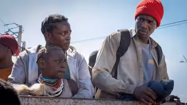 Bol Majur (Sope Dirisu), Rial Majur (Wunmi Mosaku) and Nyagak (Malaika Wakoli-Abigaba) stand among refugees