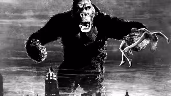 King Kong holding Ann Darrow while towering above city buildings