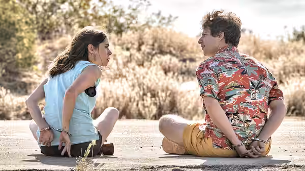 Sarah (Cristin Milioti) and Nyles (Andy Samberg) sit handcuffed together on a roadside