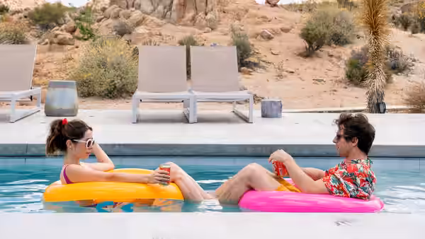 Sarah (Cristin Milioti) and Nyles (Andy Samberg) recline on inflatable rings in a swimming pool