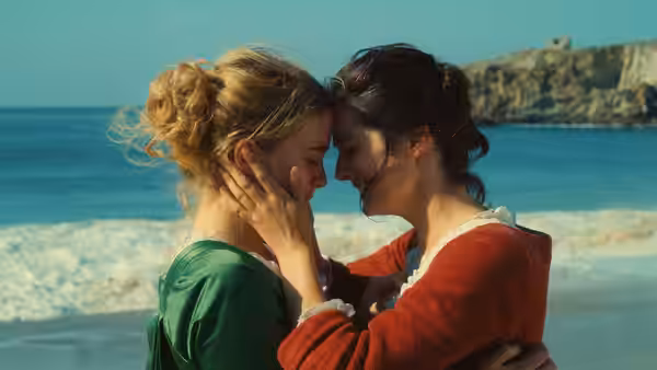 Héloïse (Adèle Haenel) and Marianne (Noémie Merlant) embrace foreheads touching on the beach