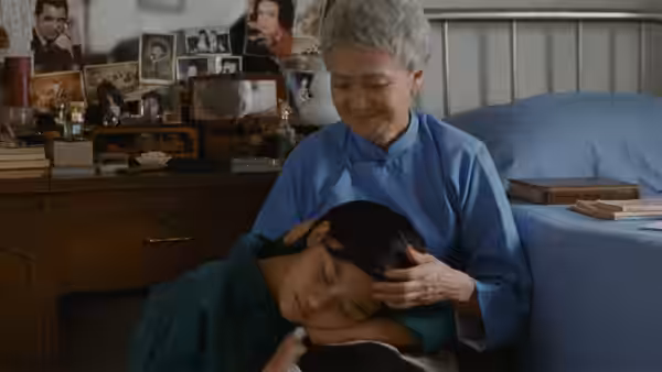 Min-Min rests her head in her mother's lap as she strokes her hair