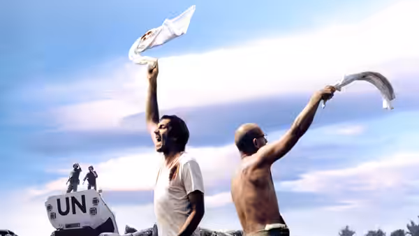 Ciki and Nino wave white cloths beside a UN armored vehicle
