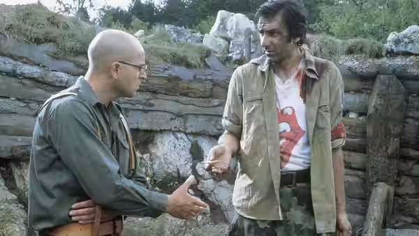 Nino (Rene Bitorajac) reaches toward bloodied Ciki (Branko Đurić) inside a ruined trench