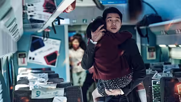 Seok-woo (Gong Yoo) carries Soo-ahn through the train aisle