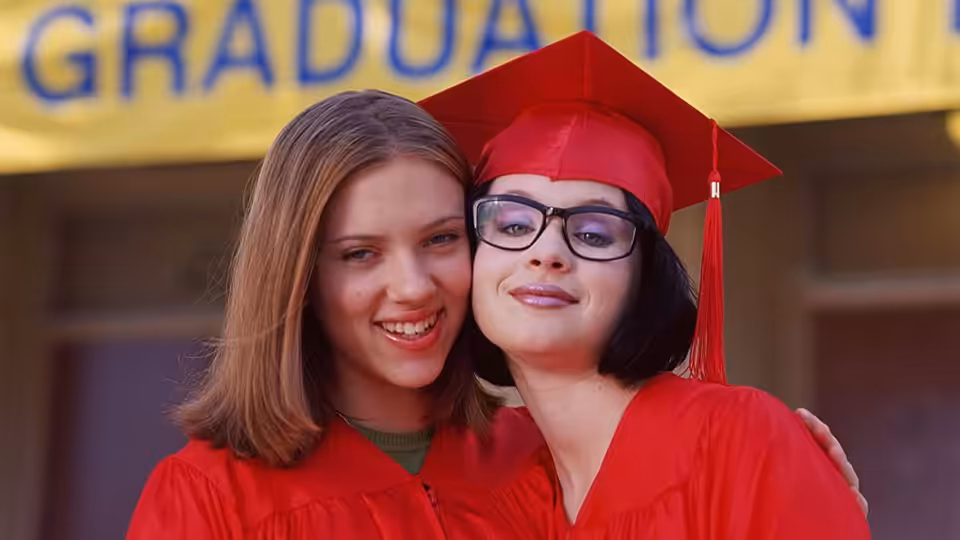 Enid (Thora Birch) and Rebecca (Scarlett Johansson) in red graduation gowns and caps