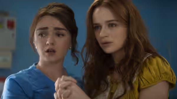 Two young women holding hands with concerned looks in a medical office