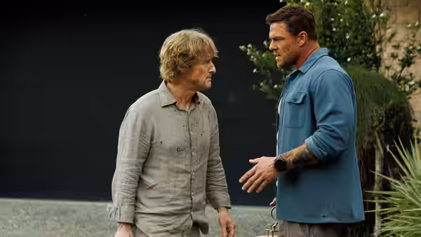 Hank Malone (Alan Ritchson) gesturing while talking to Ben (Owen Wilson)