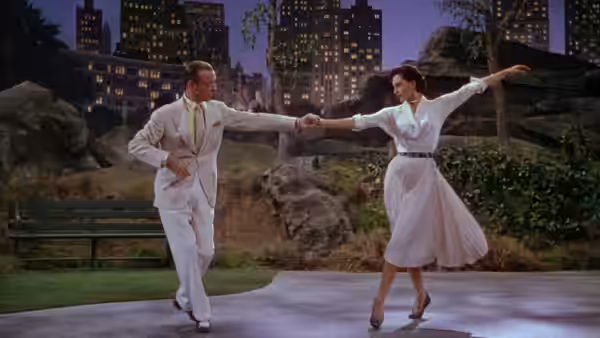 Tony Hunter and Gabrielle Gerard extend their arms toward each other while dancing outdoors