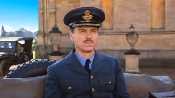 RAF officer sits on stone ledge before historic building