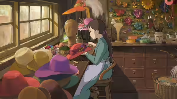 Sophie (Chieko Baishō) sewing a hat inside a sunlit millinery workshop
