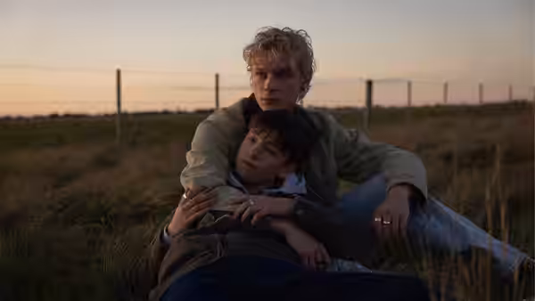 Ryan Whelan (Stacy Clausen) embracing Naim Reid (Joe Bird) in an open field