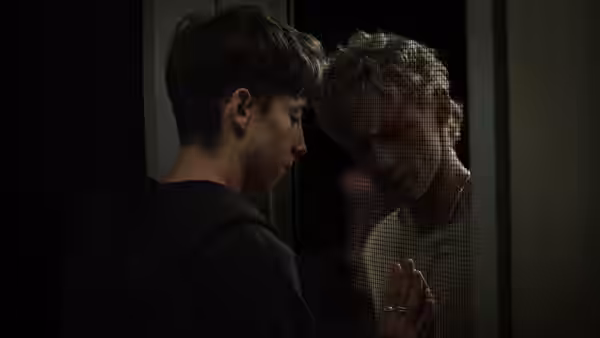 Naim Reid (Joe Bird) facing Ryan Whelan (Stacy Clausen) closely in a doorway