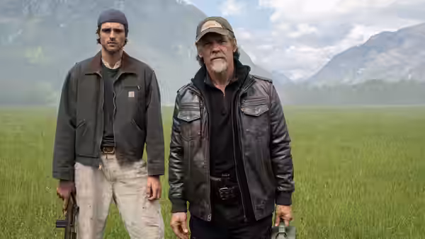 Hig (Jacob Elordi) and Bangley (Josh Brolin) standing in a grassy field