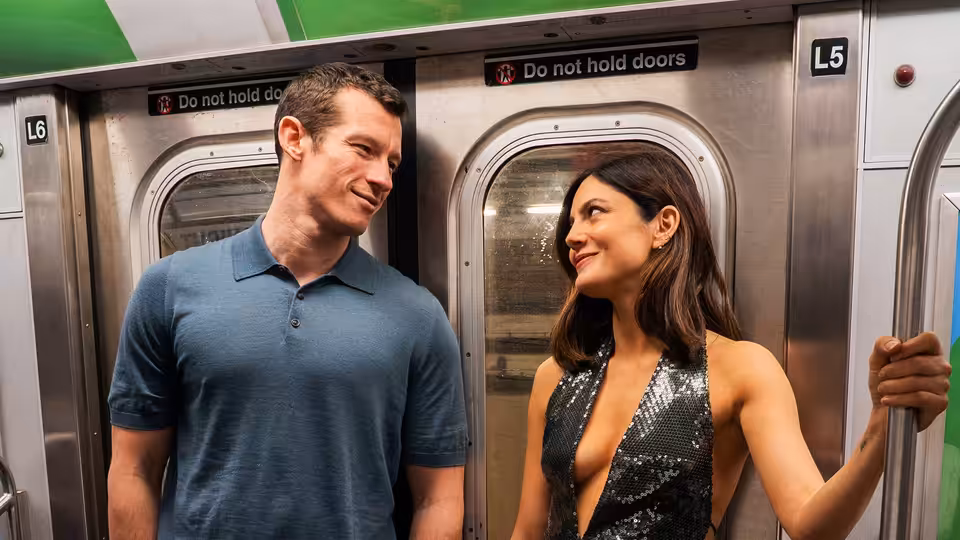Owen (Callum Turner) and Allie (Monica Barbaro) smiling together on a subway train