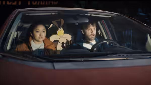 Paige Avery (Lana Condor) and Kevin Avery (Will Forte) in a car with Wile E. Coyote doll