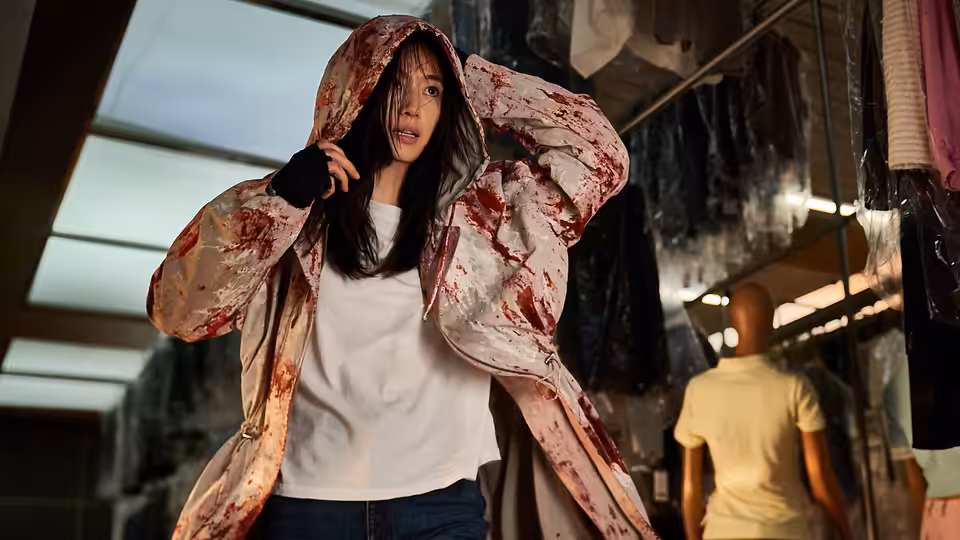 Kwon Se-jeong (Gianna Jun) adjusting her bloodied hood inside a store
