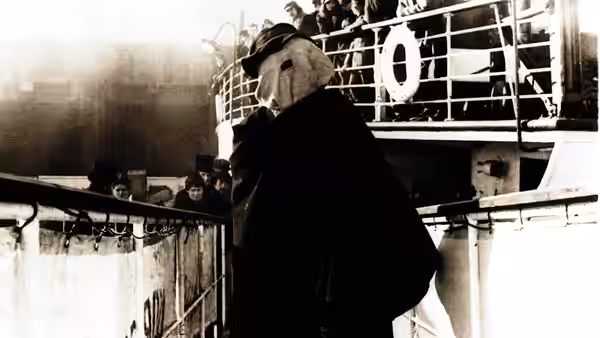 John Merrick (John Hurt) stands on a ship's deck viewed from behind