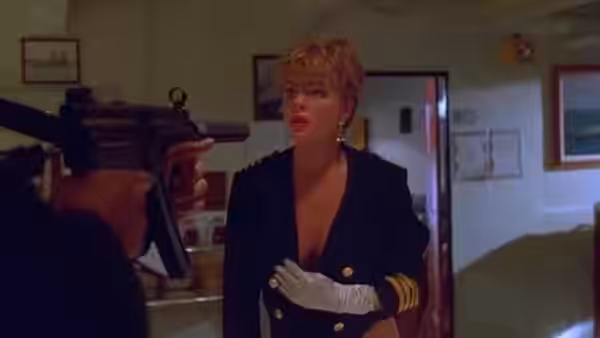 Jordan Tate (Erika Eleniak), wearing a naval uniform, faces a gunman in a doorway
