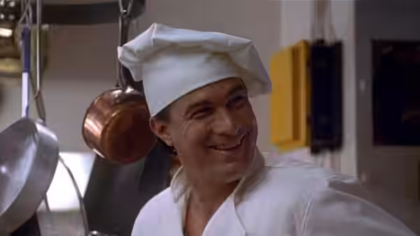 Casey Ryback (Steven Seagal) smiles in his chef's uniform in the ship's kitchen