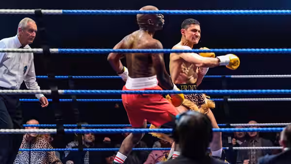 Naz (Amir El-Masry) throws a punch at his opponent in the ring