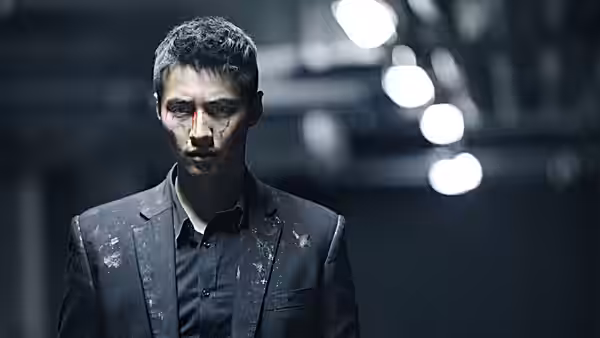 Cha Tae-sik (Won Bin), bruised and bloodied, walks through a fluorescent-lit corridor