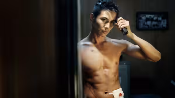 Cha Tae-sik (Won Bin), shirtless and wounded, holds a phone in a bare room