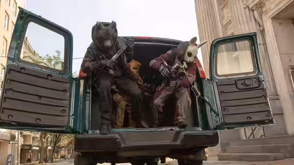 Masked figures in animal costumes holding rifles inside an open van
