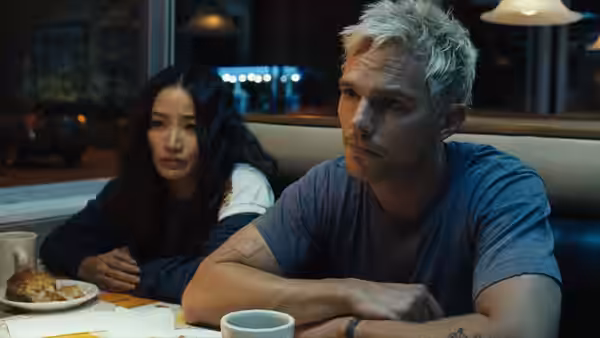 Young man and woman seated at a diner table with coffee