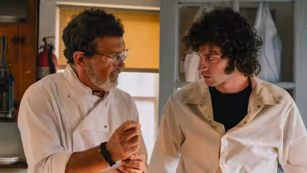 Chef (Antonio Banderas) talking with Tony (Dominic Sessa) in a kitchen