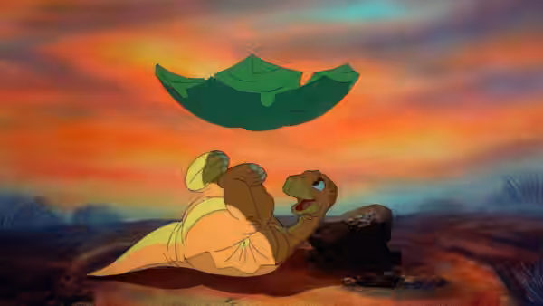 Two young dinosaurs lie beneath a floating leaf against the sunset