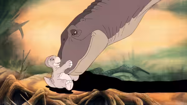 Littlefoot’s mother gently nuzzles her newborn beneath a golden sky