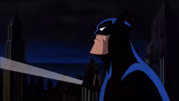Batman stands on a rooftop at night with city skyline behind