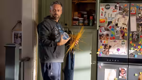 Nate Wilcox (Nate Bargatze) holding spaghetti and sauce jar in front of refrigerator
