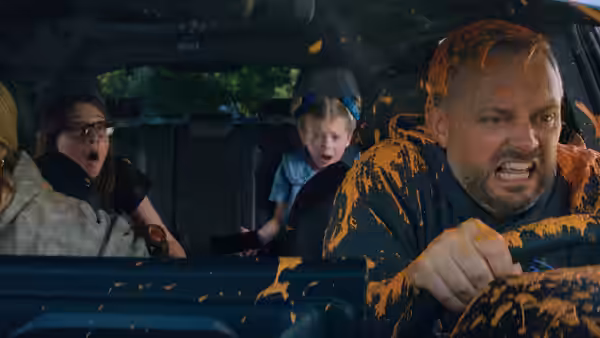 Nate Wilcox (Nate Bargatze) driving a car covered in orange substance with shocked family