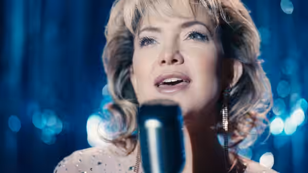 Claire Sardina (Kate Hudson) singing into a microphone on stage