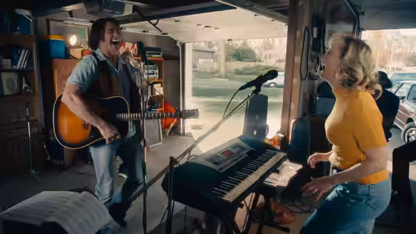 Mike Sardina (Hugh Jackman) playing guitar while Claire Sardina (Kate Hudson) dances in a garage
