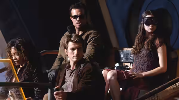 Jayne Cobb (Adam Baldwin) and River Tam (Summer Glau) seated inside the ship