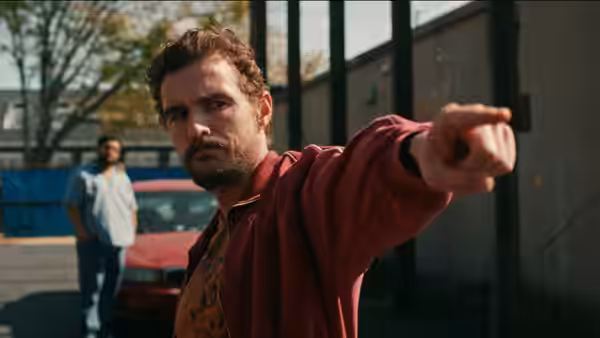 Mark pointing forward in a parking lot with another man behind
