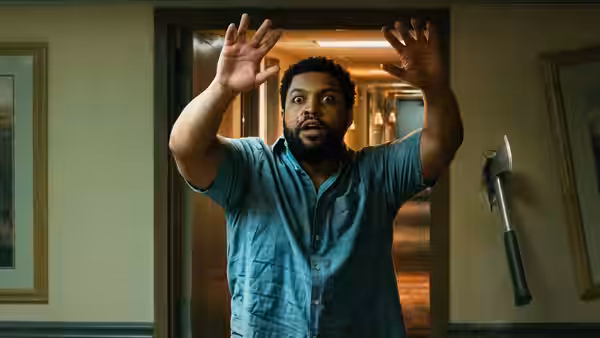 Davis standing in a hallway with both hands raised high