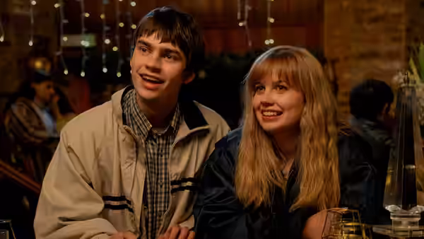 Owen (Spike Fearn) and Emily (Angourie Rice) smiling together at a restaurant table