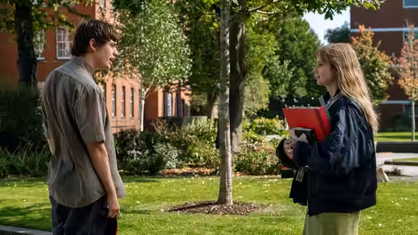 Owen (Spike Fearn) and Emily (Angourie Rice) facing each other on a university lawn