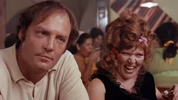 Tully (Stacy Keach) sits beside Oma (Susan Tyrrell) in a crowded bar